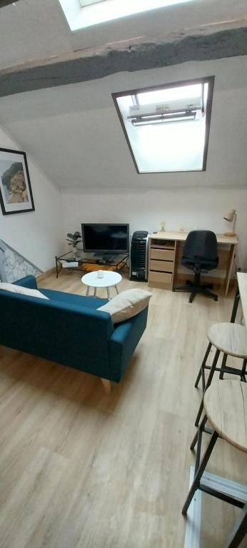 a living room with a couch and a desk at Studio Arc en Ciel in Bouguenais