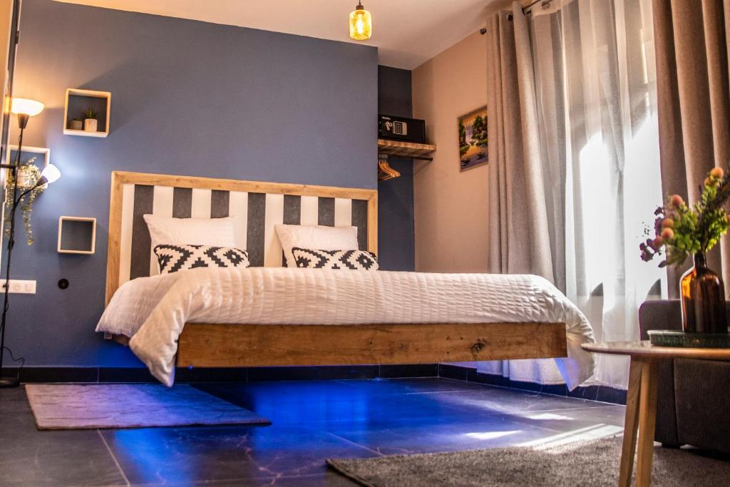 a bedroom with a bed with a blue floor at Maison Caliya in Saint-Didier-en-Velay