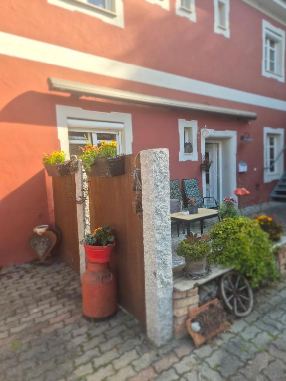 a house with potted plants on the side of it at Ferienwohnung Meyer in Kinding