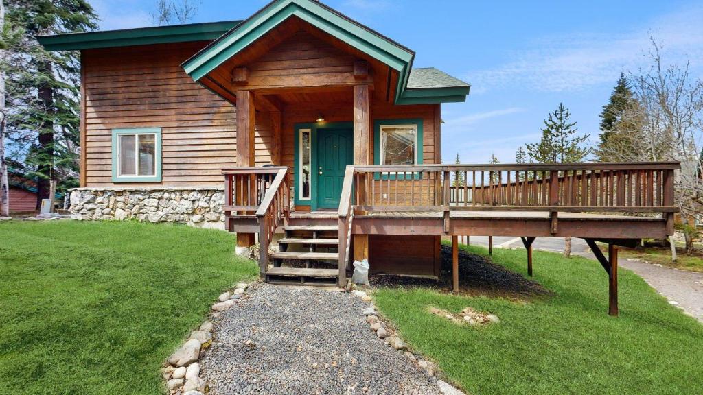 a log cabin with a porch and a green door at Spring Mountain Condo Pool Gym Slopes in McCall