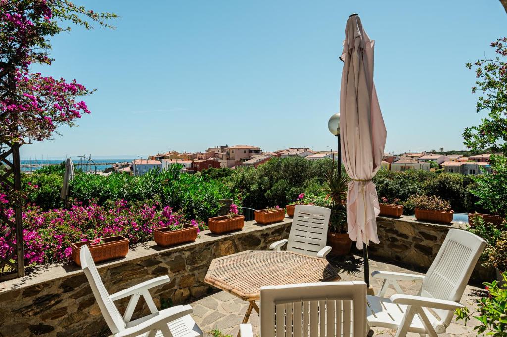 a patio with a table and chairs and an umbrella at Casa Levante - 3 camere, veranda e vista mare in Stintino