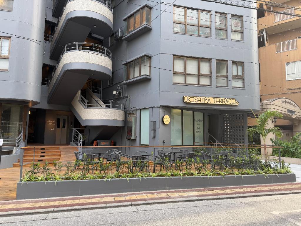 a building with tables and chairs in front of it at Kokusai Towns Inn in Naha