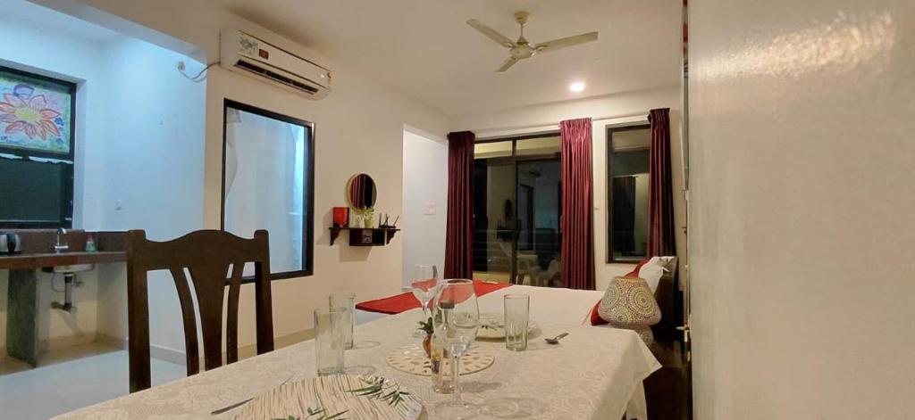 a dining room with a table with a white table cloth at Hotel Wave Morjim in Morjim