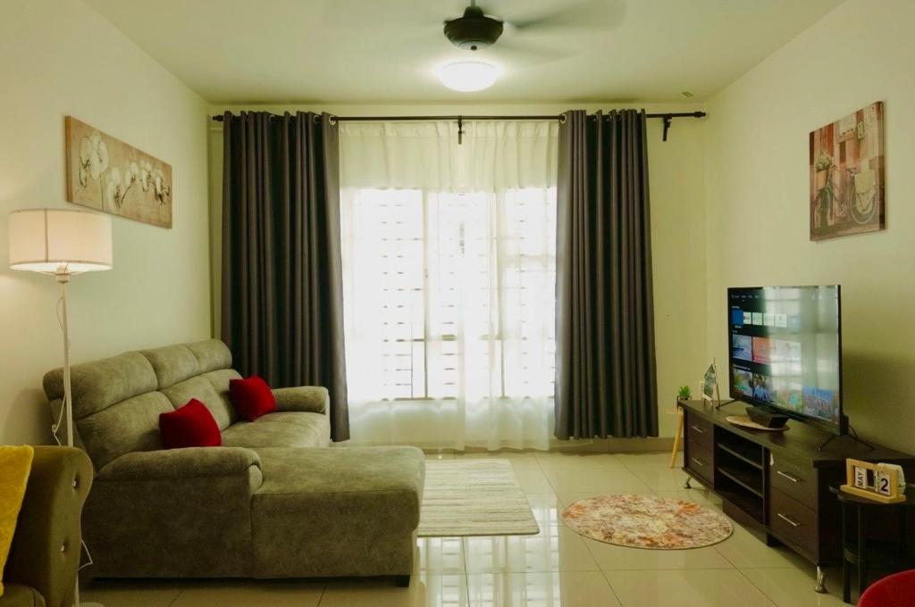 a living room with a couch and a television at AmyHana Cozynest in Putrajaya