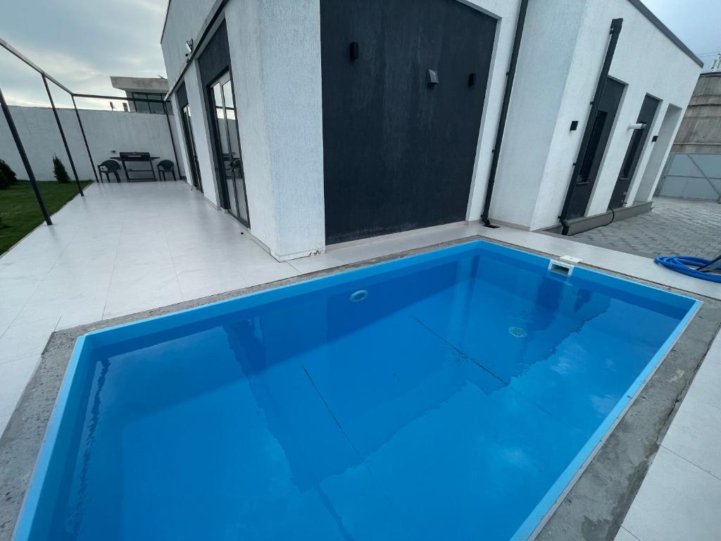 a large blue swimming pool on the patio of a house at House by River in Yerevan
