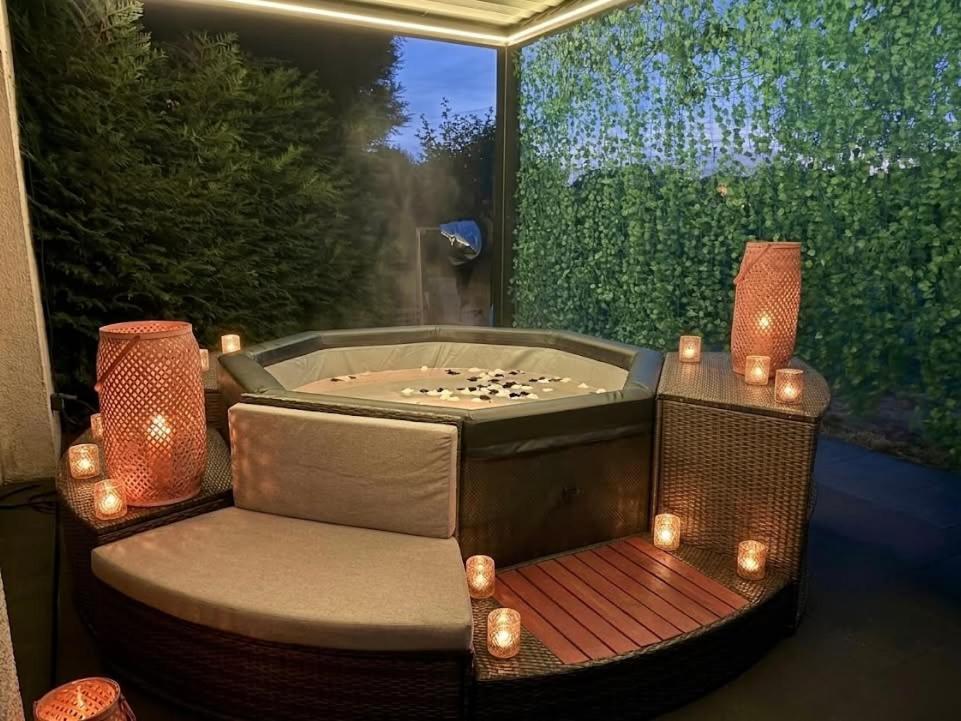 a jacuzzi tub with a chair and a table at Jacuzzi privatif Appartement premium Vendôme in Vendôme