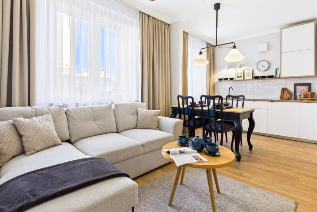 a living room with a couch and a table at Apartament 101 in Piła