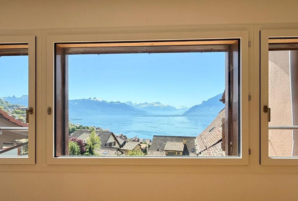 a window with a view of the mountains at Vue imprenable Léman - Cosy à Chexbres in Chexbres