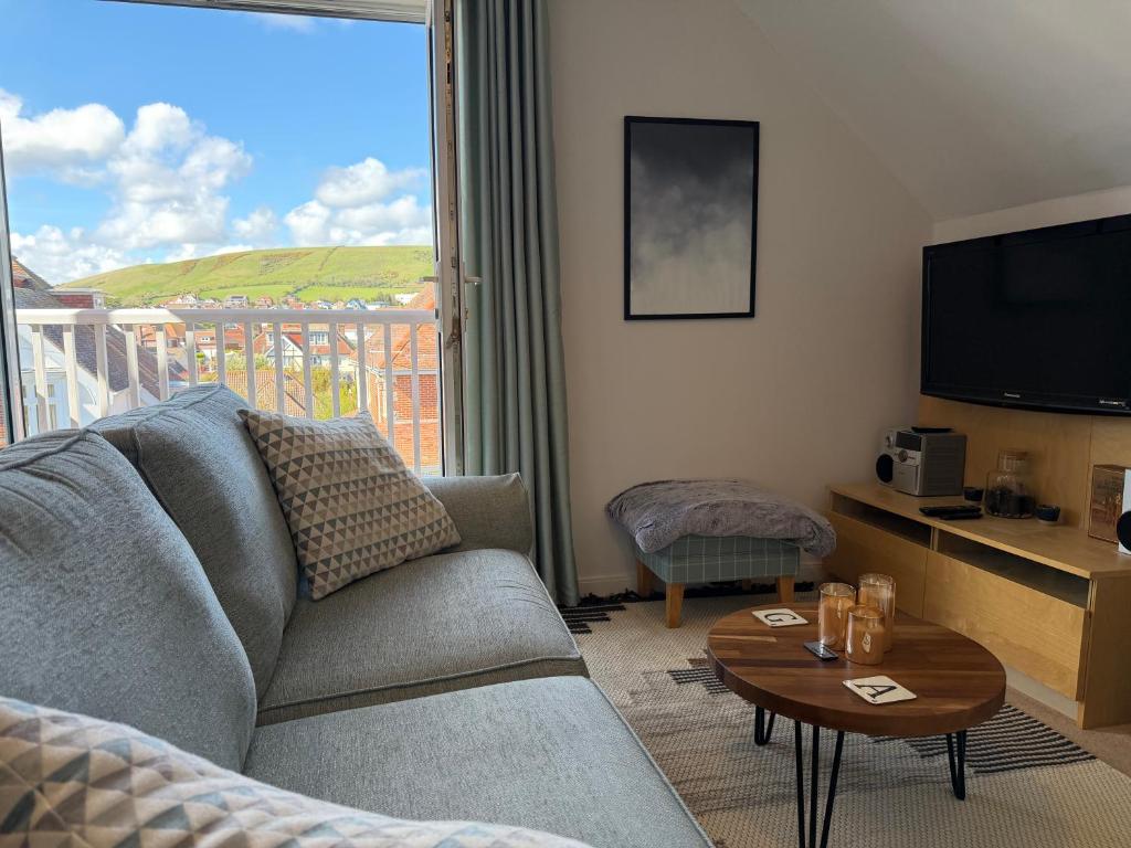 a living room with a couch and a tv and a table at Ballard Down View, Swanage 2 Bed in Swanage