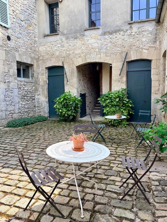 a patio with a table and chairs in front of a building at Appartements 56 in Senlis