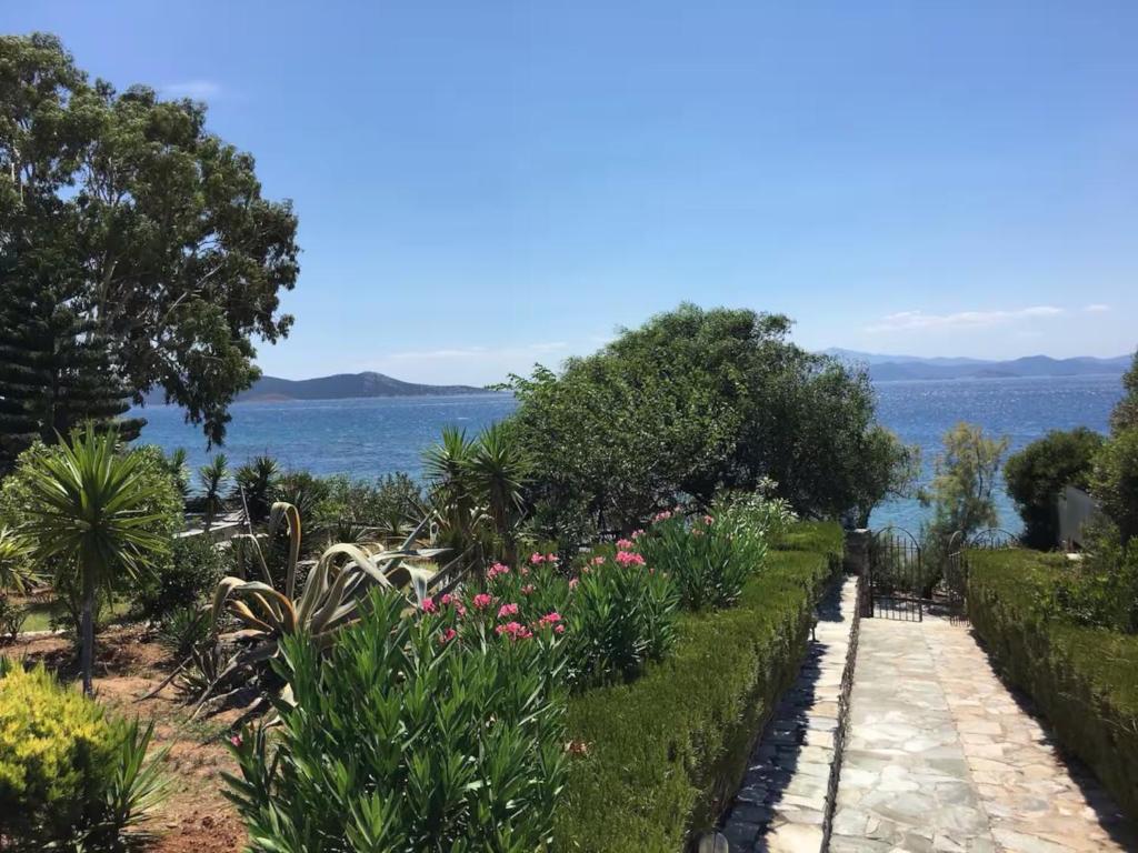 a garden with a view of the water at Seafront House, Private Beach, Sunset View, Diliso in Vathírrevma