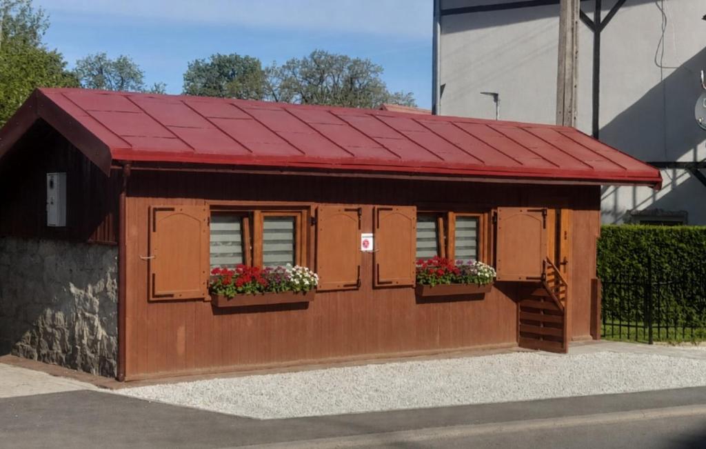 a building with windows and a red roof at Chatka Czesia in Sosnówka