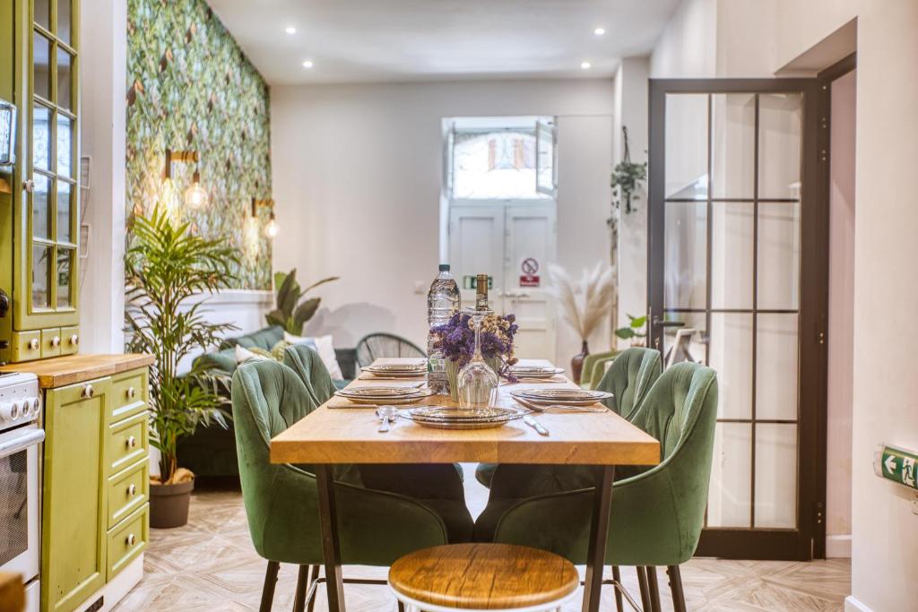 a dining room with a table and green chairs at Eclectic Maisonette in Luqa in Luqa
