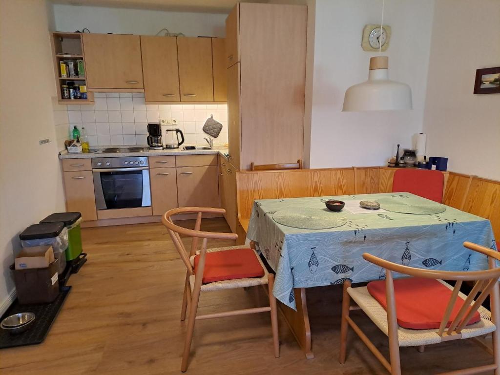 a kitchen with a table and two chairs and a table and a kitchen at Ferienwohnung Gitta in Helmstorf