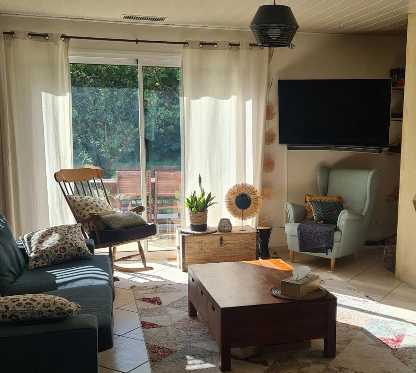 a living room with a couch and a tv at Propriété avec piscine in Vensac