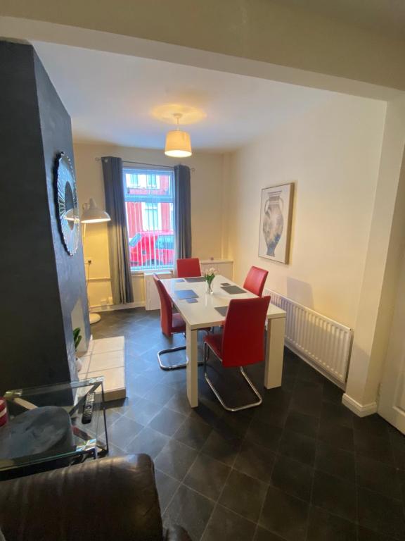 a dining room with a table and red chairs at spamount house in Belfast