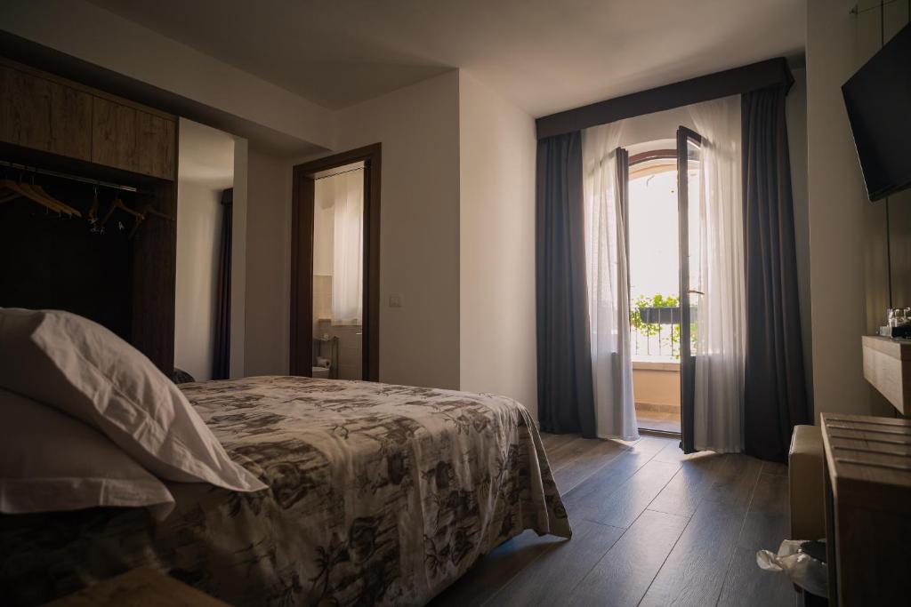 a bedroom with a bed and a sliding glass door at Albergo Pineta dal 1891 in Villetta Barrea