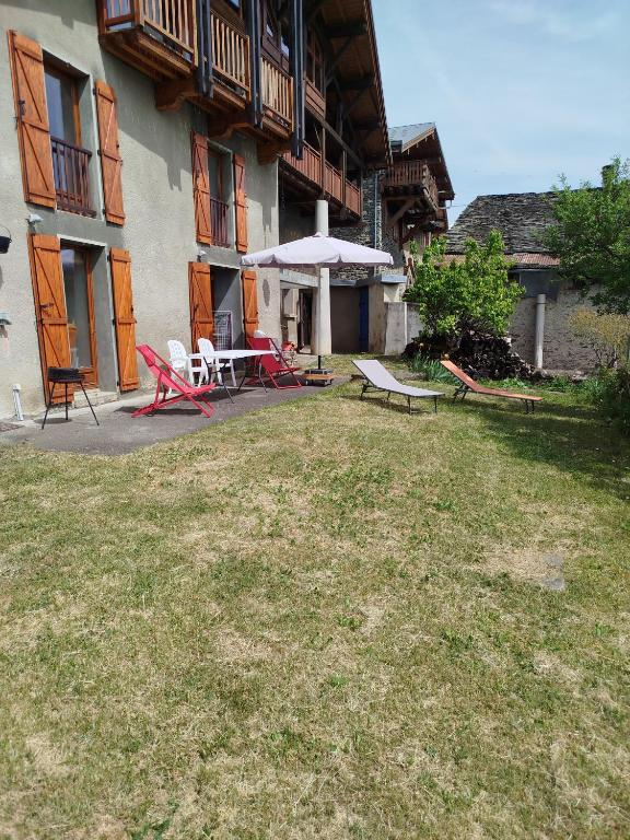 a yard with chairs and tables and a building at Les Balcons de Valezan in La Plagne Tarentaise
