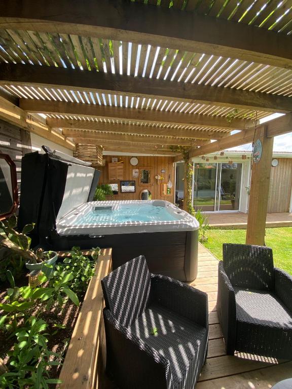a patio with a pool table and two chairs at Maison familiale Tarnos, 4 chambres, jacuzzi in Tarnos
