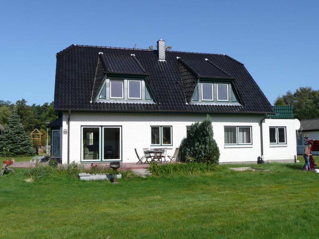 a white house with a black roof at An der Sonnenwiese in Prerow
