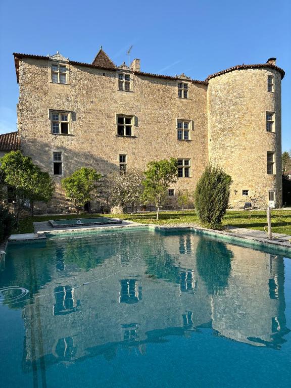a large building with a pool in front of it at Château de Fourcès in Fourcès