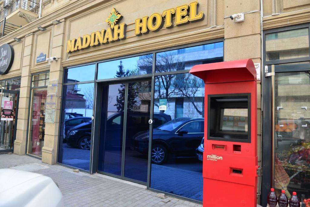 a red phone booth in front of a hotel at Madina-ZamZam Halal Hotels Group in Baku