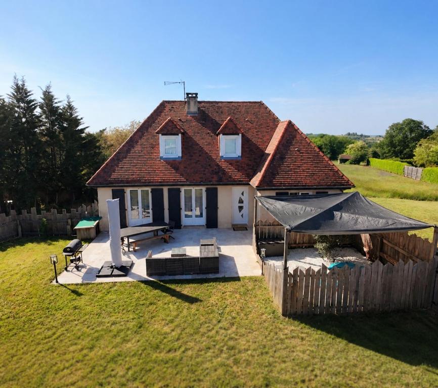 a small house with a fence in a yard at Maison Salignac 9 personnes in Salignac Eyvigues