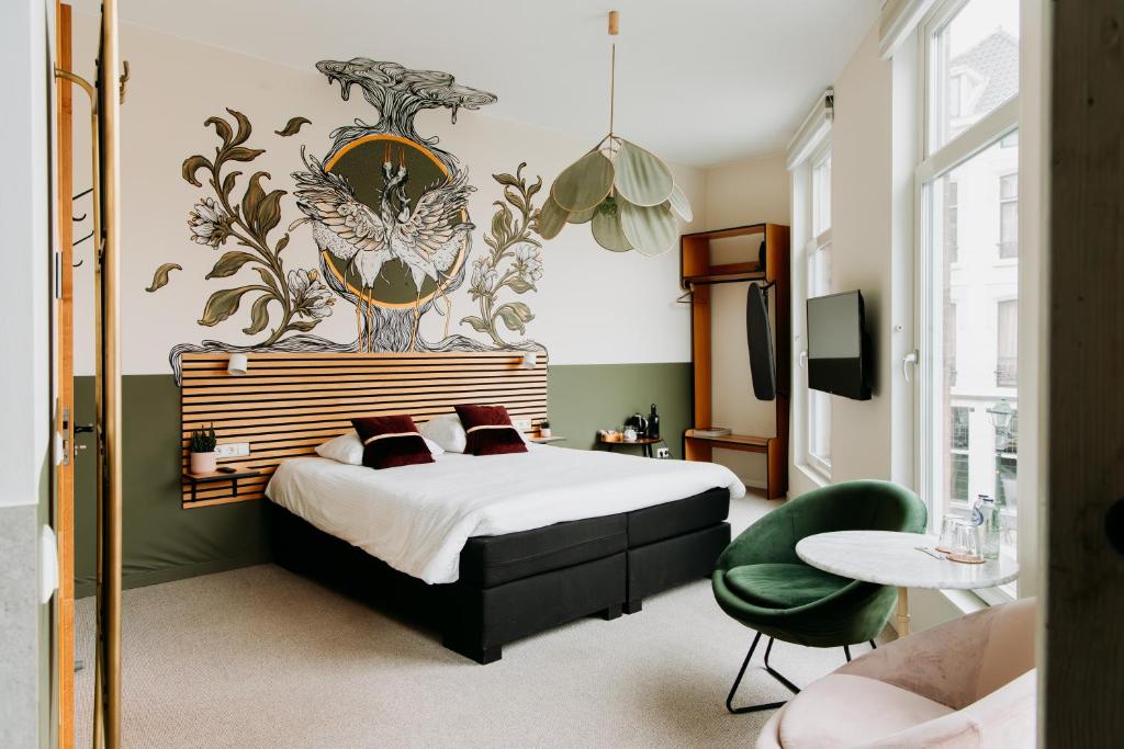 a bedroom with a bed and a table and a chair at La Paulowna Boutique Hotel in The Hague