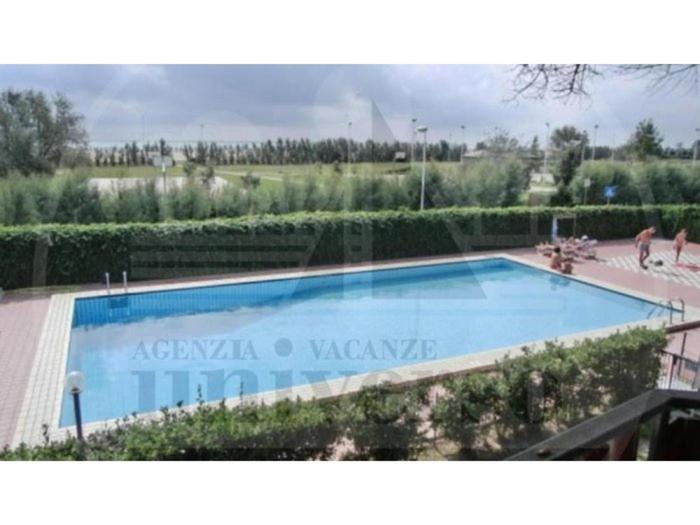 a large blue swimming pool in a resort at Sotto il Pino 14 in Eraclea Mare