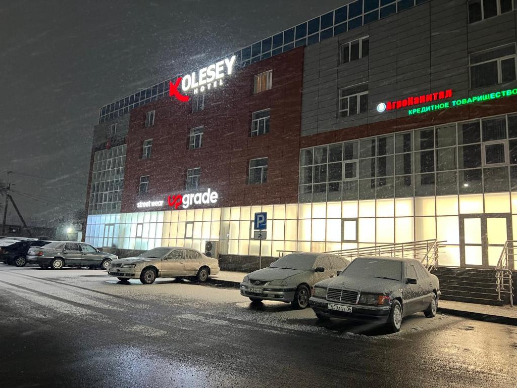 a group of cars parked in front of a building at KOLESEY Hotel in Taldykorgan
