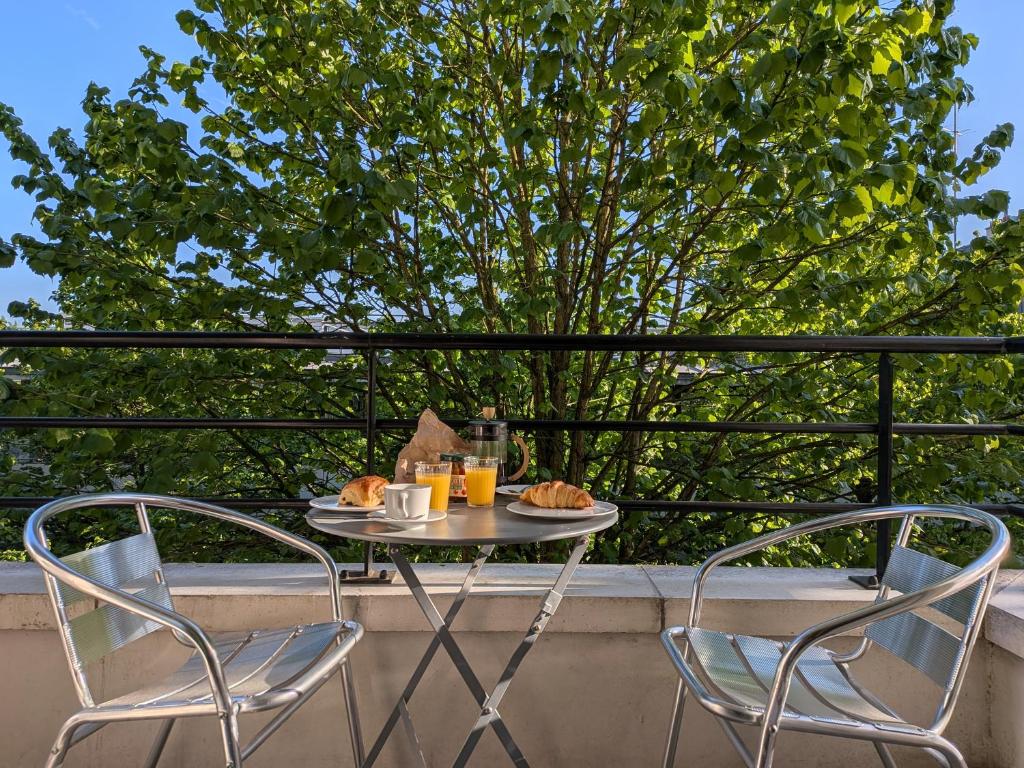two chairs and a table with food on a balcony at Le Jourdain in Paris