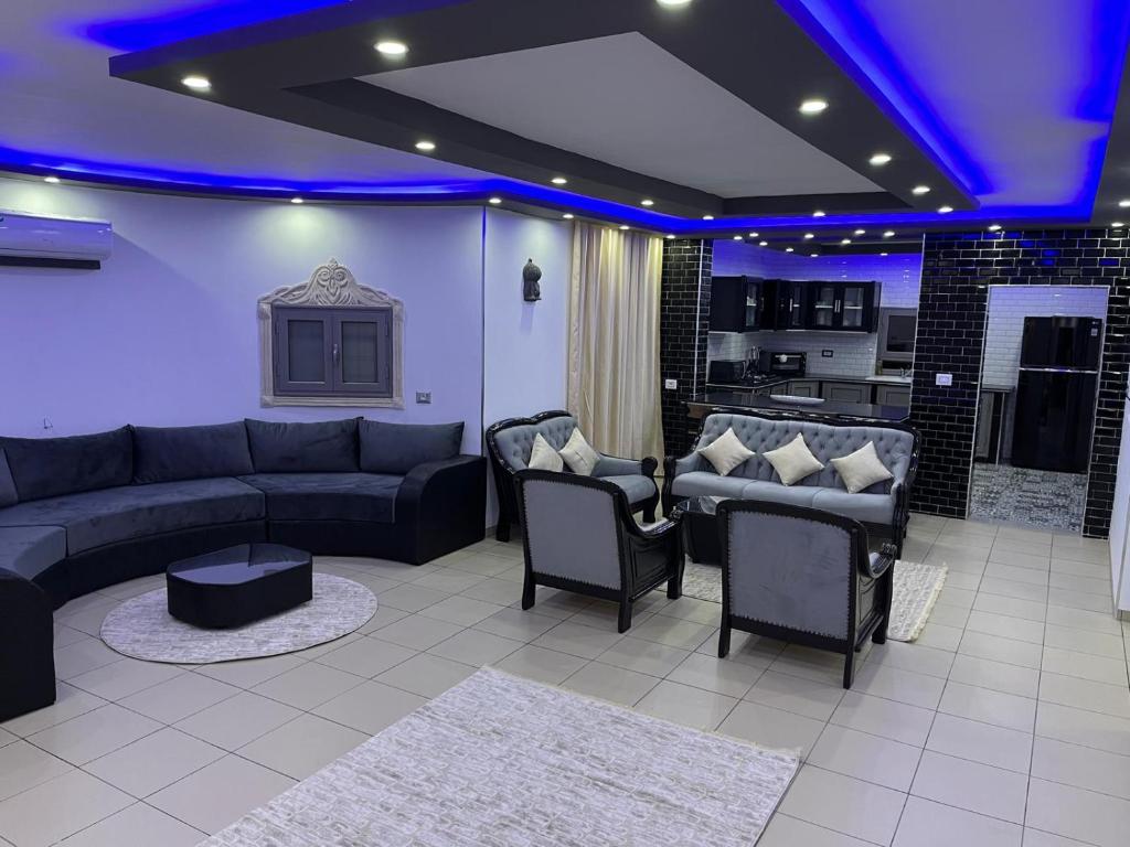 a living room with a couch and chairs and a kitchen at Villa BBS in Ghlissia