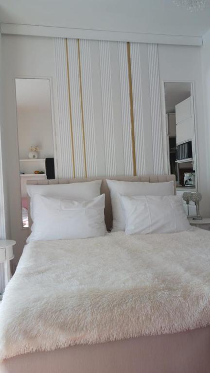 a white bed with white pillows and a white blanket at Uzdrowiskowa "Trzy Korony" in Świnoujście