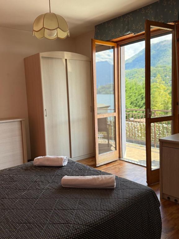 a bedroom with a bed with a large window at Hotel Mezzolago in Calceranica al Lago