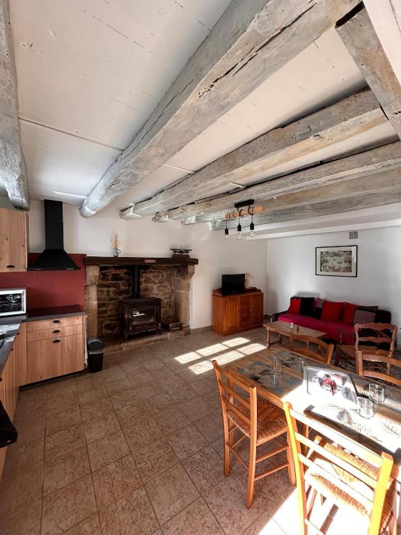 a kitchen and living room with a table and chairs at Maison Lilas in Pontarion