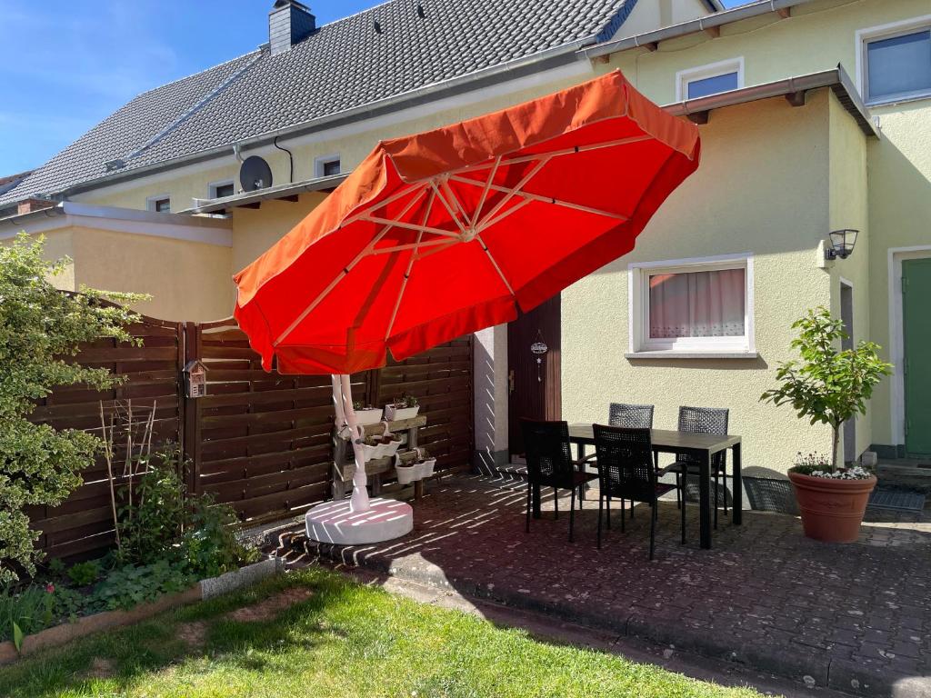 a red umbrella in the yard of a house at Ferienwohnung Gisela in Lohsa