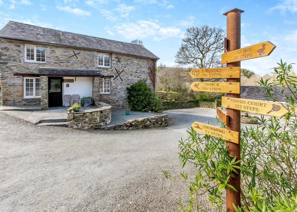 a directional sign in front of a stone cottage at Kilminorth Cottages in Trelaske