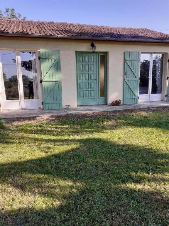 a house with a green door and a yard at Maison campagne in Charron