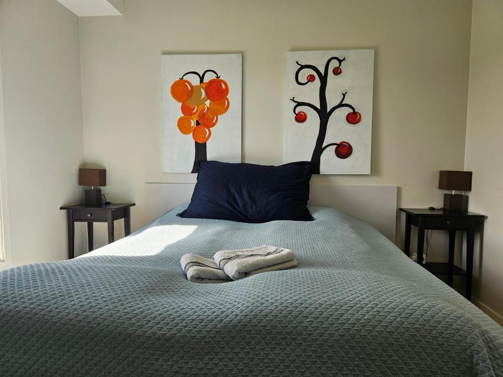 a bedroom with a bed with a blue pillow and orange decorations at Dugneberg in Karmøy