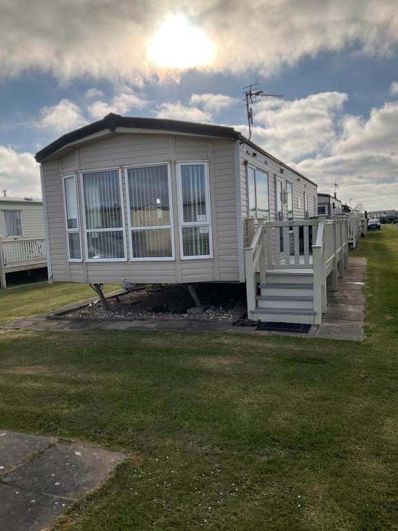 a large white house with a porch and a yard at Konies Place Golden Anchor Free WiFi Bedding Included in Chapel Saint Leonards