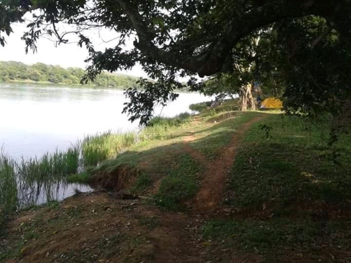 a dirt road next to a body of water at Rancho dos dourados in Três Marias
