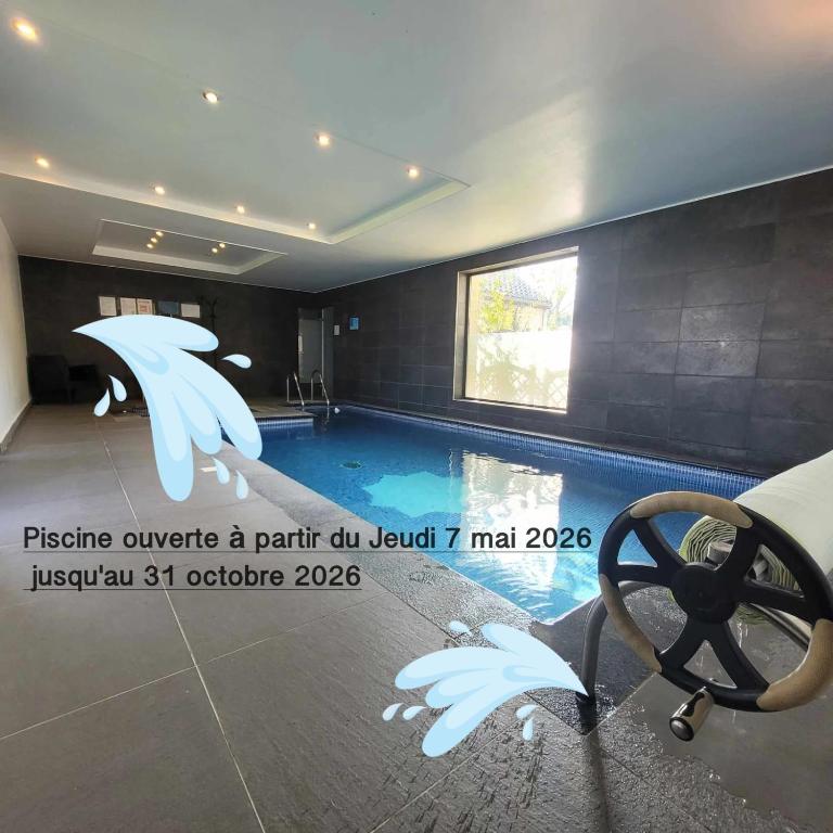 a room with a swimming pool with white wings at Le gite du chtihameau avec piscine intérieure privative, selon date in La Bassée