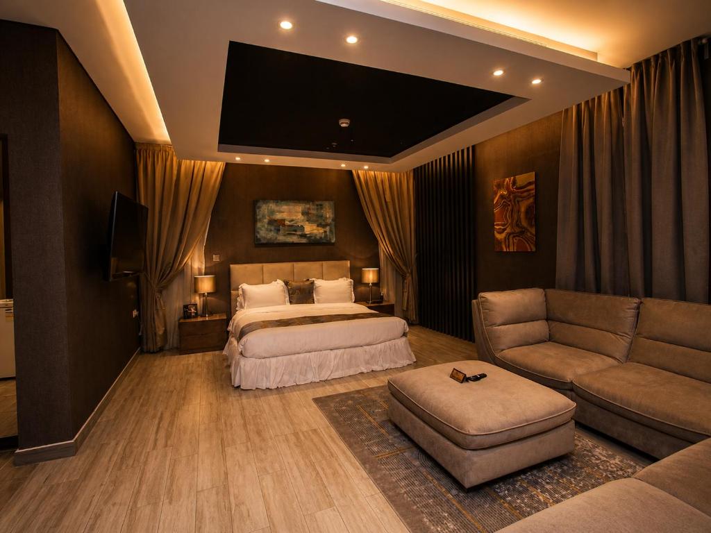a bedroom with a bed and a tv and a couch at مسكن نون للشقق المخدومة in Jeddah
