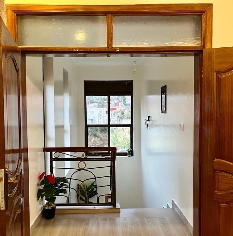 a hallway with a door open to a room with a window at KiGALI COMFORT AND CLASSIC STAY APARTMENT in Kigali