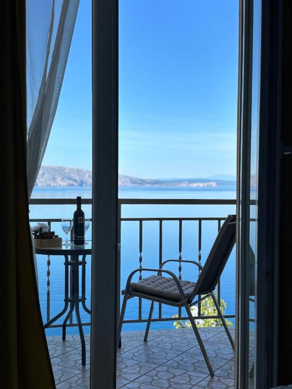 a room with a balcony with a table and a chair at Apartments New Charming in Senj