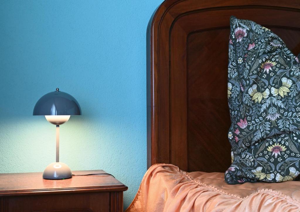 a bed with a pillow and a lamp on a table at auf der Muehle zwei in Zerbst