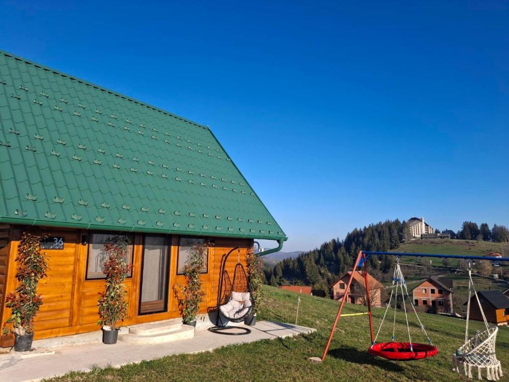 a house with a green roof and a swing at Brvnara Zoja - Zlatar in Prorečane