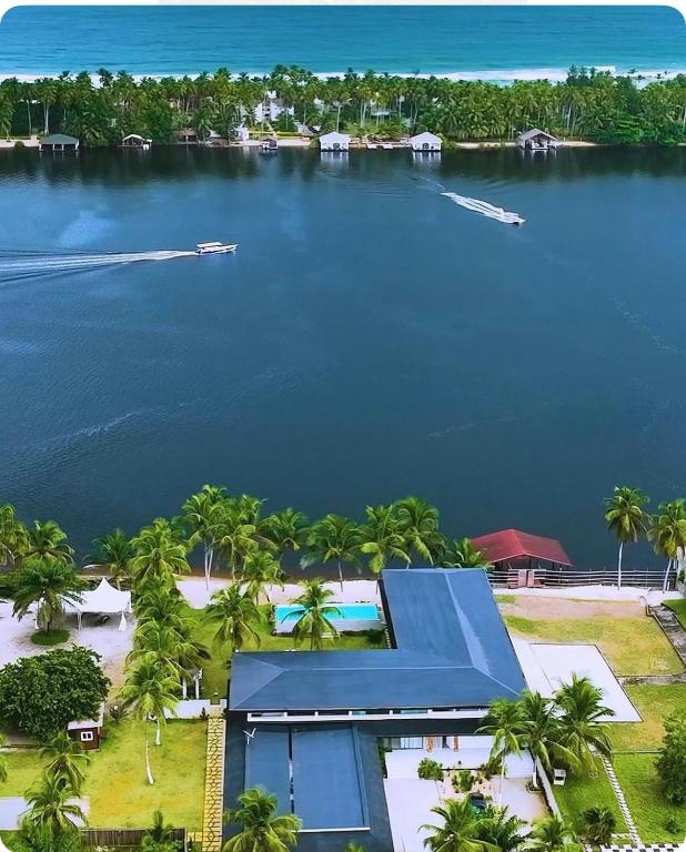 an aerial view of a resort with a boat in the water at Hôtel Touraco in Assinie