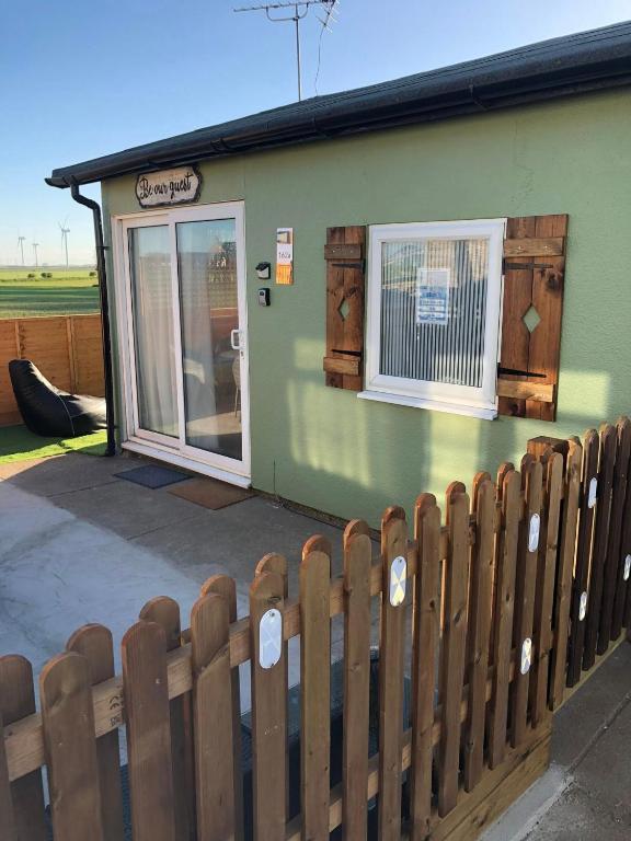 a green building with a fence in front of it at Field View 162a fifth Ave in Bridlington