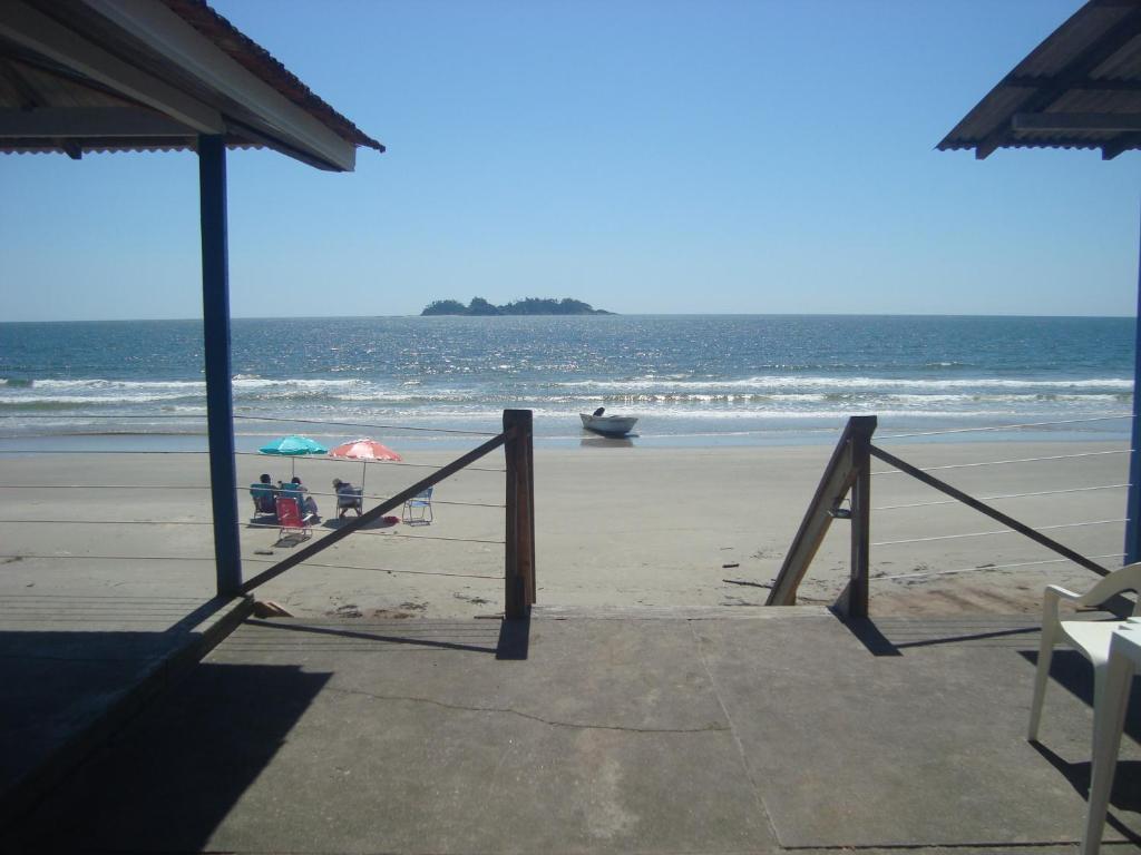 a beach with umbrellas and people on the beach at Dona Quinota in Ilha do Mel